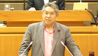 本会議場で委員長報告を行う高柳議員